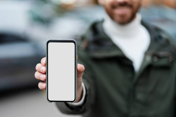 istock Positive, bearded man shows a smartphone with a touchscreen. Clean screen, space for ads. 1466967918