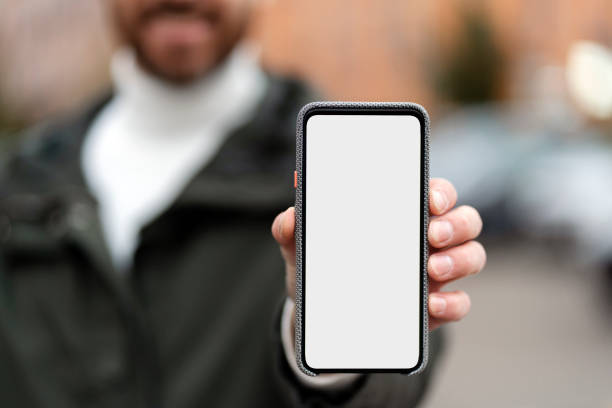 istock Bearded man shows a smartphone with a touchscreen. Clean screen, space for ads. 1466967982
