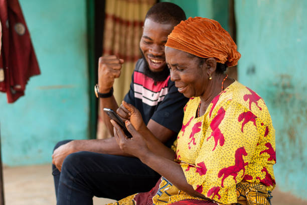 istock Young black man assisting an elderly black woman using her phone 1466968736