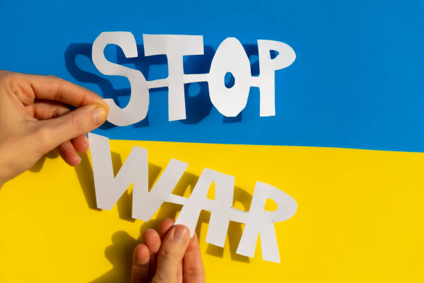 istock Woman's hand holding a stop war text with the conflict between Ukraine and Russia 1466971976