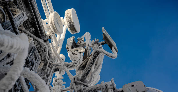 A low angle view of satellites in winter against blue sky