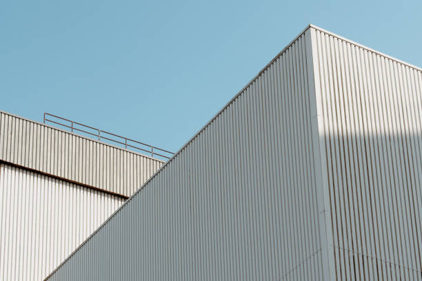 istock Diagonal, fragmentary view of light-colored warehouses with corrugated iron facades in the port, against a blue sky 1466972782