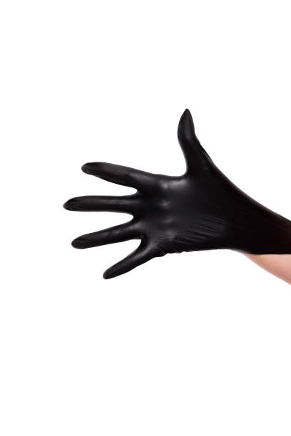 Woman puts on black rubber gloves, only hands on white background Vertical stock photo