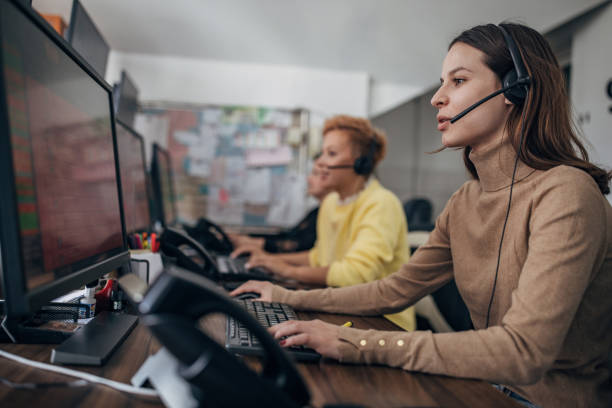 Taxi service operators working Two women, female taxi service operators with headsets working in call center on computers. dispatcher stock pictures, royalty-free photos & images