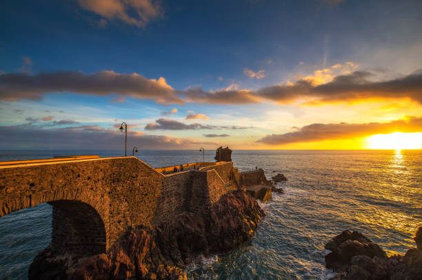 Sunset at the pier of Ponta do Sol in Madeira Island, Portugal stock photo