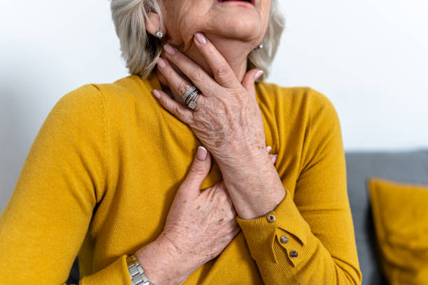 istock An older grey-haired woman with chronic medical problems is desperate while struggling with choking and pain in her throat. 1466981160