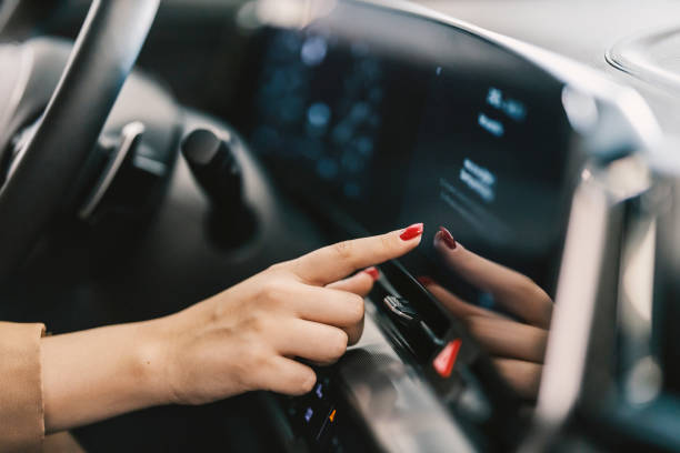 nahaufnahme einer weiblichen hand, die den touchscreen im auto drückt. - armaturenbrett stock-fotos und bilder