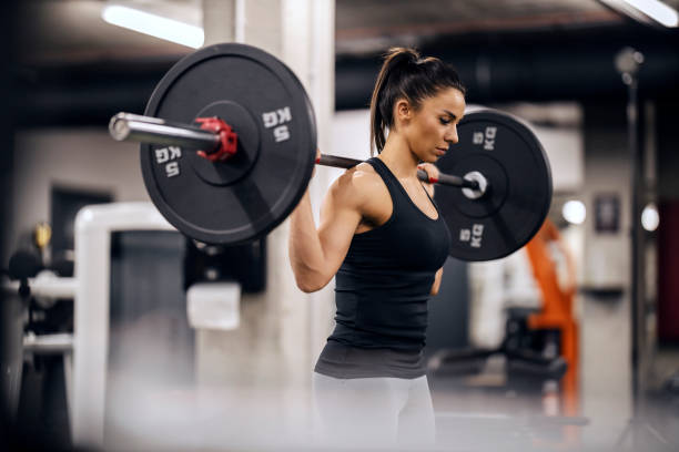 istock A muscular female bodybuilder is lifting weights in gym. 1466988679