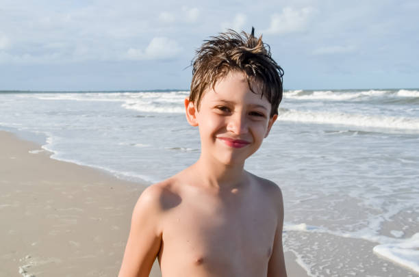 Cute smiling boy posing for photo on the beach. City of Valenca, Bahia.