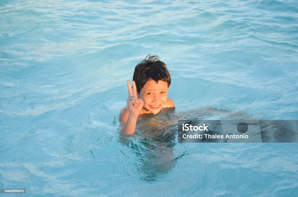 Funny happy boy playing in the pool. Funny happy boy playing in the pool. Vacation. 6-7 Years Stock Photo