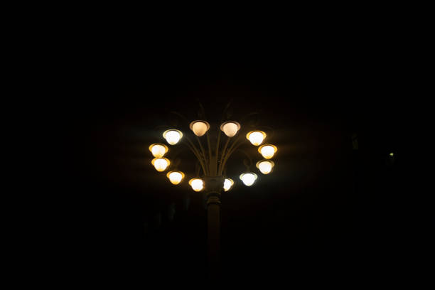 High pole with spotlights at night. Stand with lamps. Lots of light sources. Urban infrastructure.