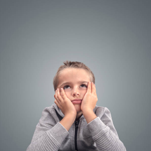 istock Bored and fed up boy with head in hands in despair 1466991845