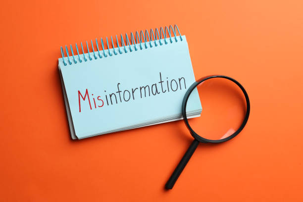 istock Notebook with word MISINFORMATION and magnifying glass on orange background, flat lay 1466993935