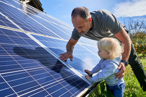 istock Man shows his small child the solar panels during warm day 1466995150
