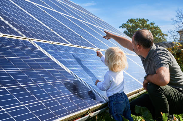 istock Man shows his small child the solar panels during warm day 1466995169
