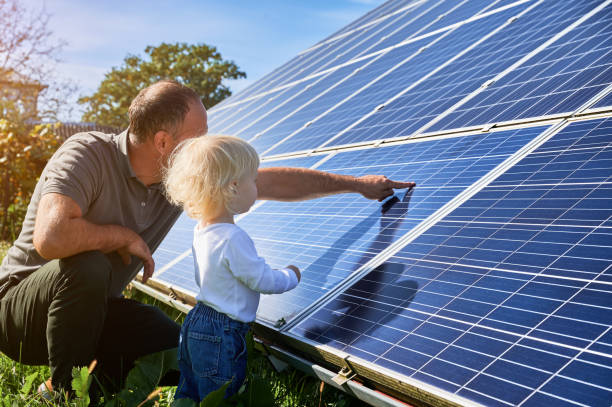 istock Man shows his small child the solar panels during warm day 1466995189