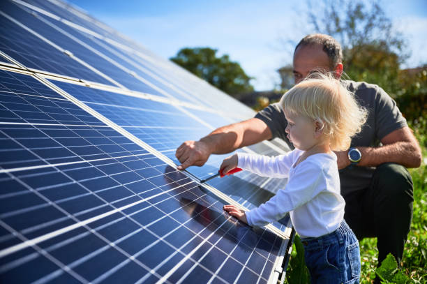 istock Man showing his small child the solar panels during warm day 1466995203