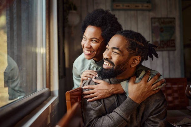 istock Happy black couple looking through window from home. 1466995697