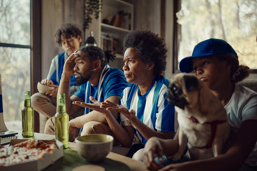 African American family feeling frustrated after their favorite soccer team has lost the match.