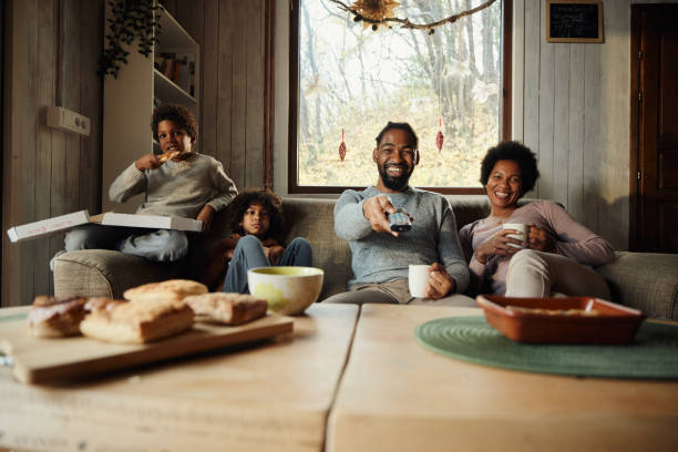 istock Happy black family enjoying while watching TV at home. 1466996313