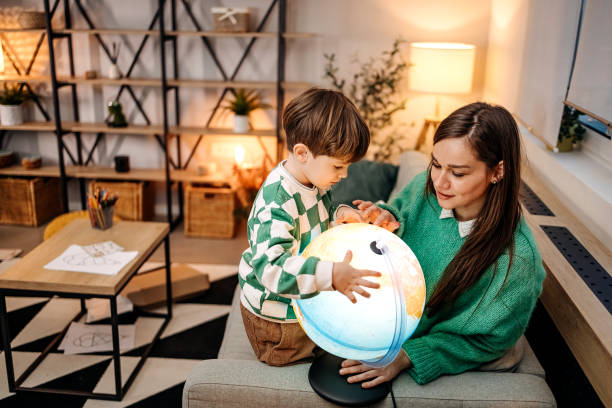 istock Little boy with his mother looking at globe 1466997306