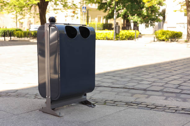 istock Modern metal recycling bin on city street. Space for text 1466997314