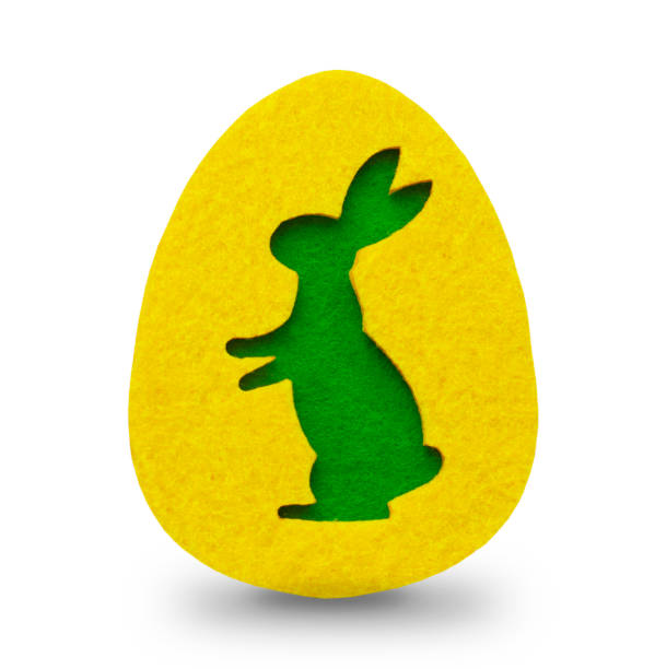 on a yellow felt egg silhouette of a green rabbit, Easter concept, isolated on white