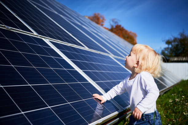chico curioso investigando cómo funciona la batería solar. - solar panel engineer solar power station solar energy fotografías e imágenes de stock