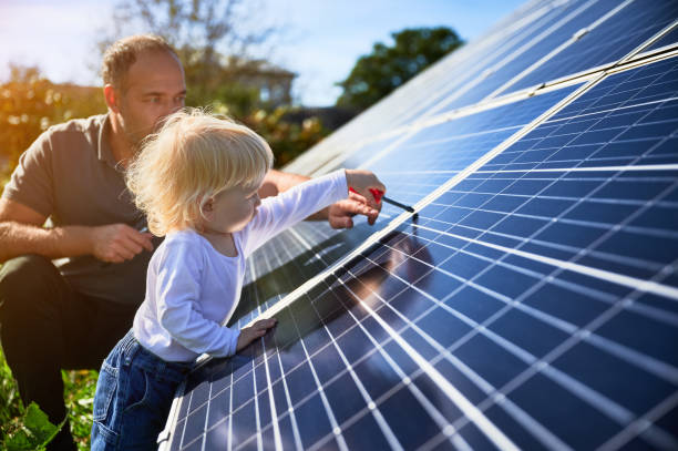istock Man showing his small child the solar panels during warm day 1466998807