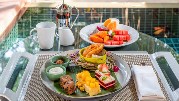 istock Tropical desserts, cakes, and fruits on a table set with plates. 1467000092