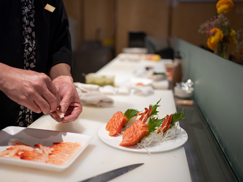 The chef is laying out salmon fillets