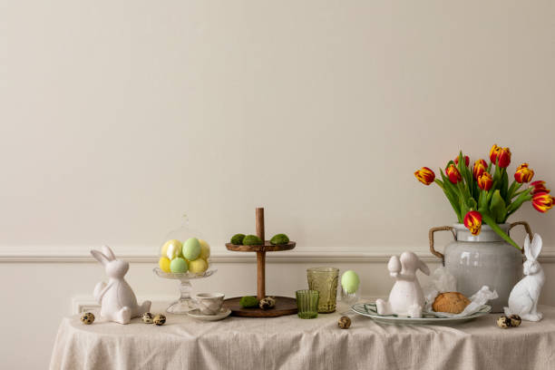 istock Creative composition of easter living room interior with copy space, vase with spring tulips, easter bunny sculpture, elegant cup, colorful easter eggs and personal accessories. Home decor. Template. 1467002192