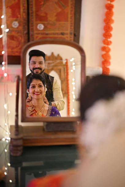 istock Indian mature couple smiling and looking in a wooden mirror while getting ready for a traditional festival 1467002201