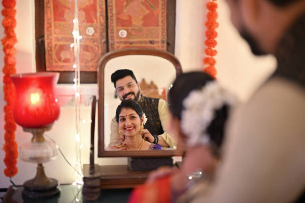 istock Indian mature couple smiling and looking in a wooden mirror while getting ready for a traditional festival 1467002204