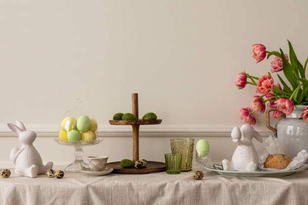 istock Creative composition of easter living room interior with copy space, vase with spring tulips, easter bunny sculpture, elegant cup, colorful easter eggs and personal accessories. Home decor. Template. 1467002258