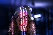 Computer code projected on young woman's face