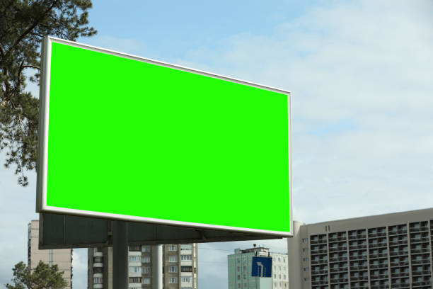 istock Chroma key compositing. Big empty billboard with green screen in city. Mockup for design 1467013260