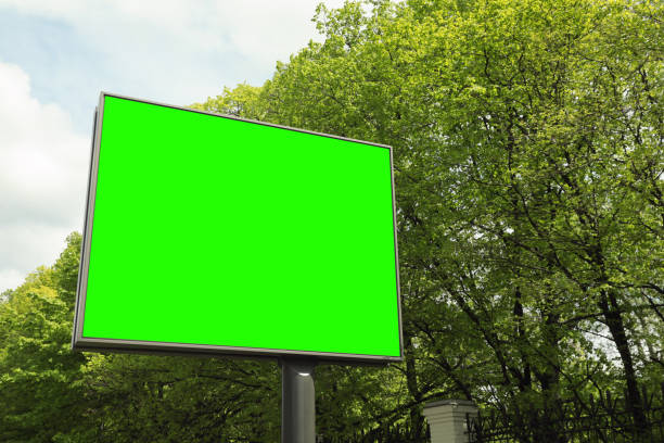 istock Chroma key compositing. Big empty billboard with green screen outdoors. Mockup for design 1467013839