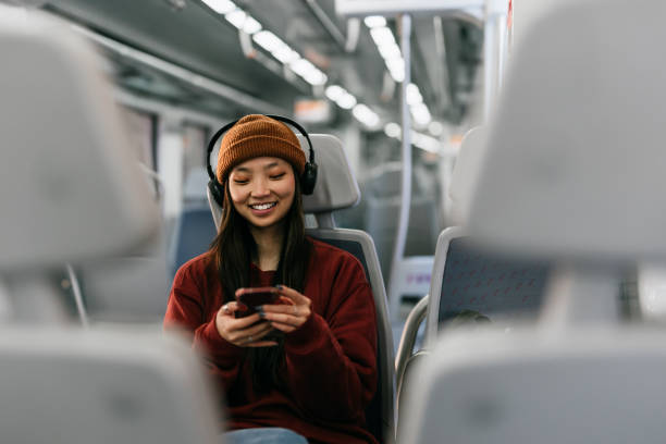 Beautiful woman using phone in train stock photo