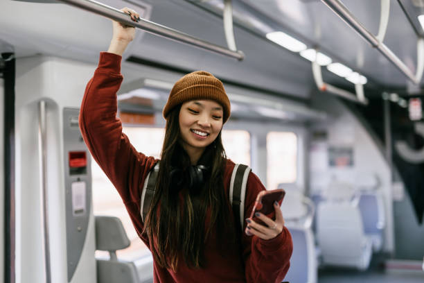 istock Beautiful woman using phone in train 1467015119