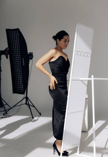 istock Young woman looks in her reflection on mirror and admires yourself in studio. 1467016592