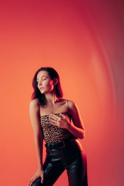 istock Young woman poses in studio against orange background. 1467016665