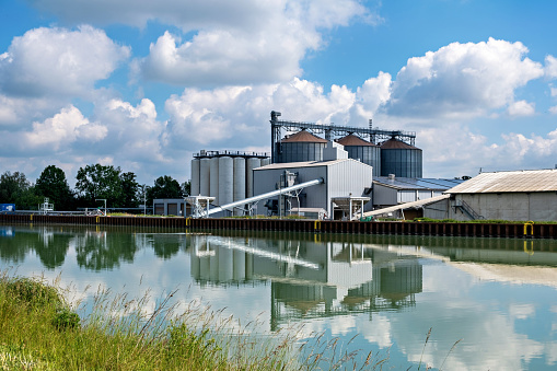 Agro-processing facility for processing, drying, cleaning and storing agricultural products, flour, cereals and grain. Barn elevator on the bank of the canal.