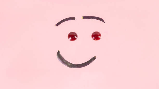 istock Smiley face made from purple asparagus beans and cherries. 1467020862