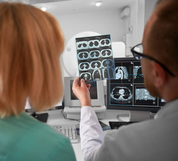 Doctor and nurse sitting at computer, looking at MRI results.