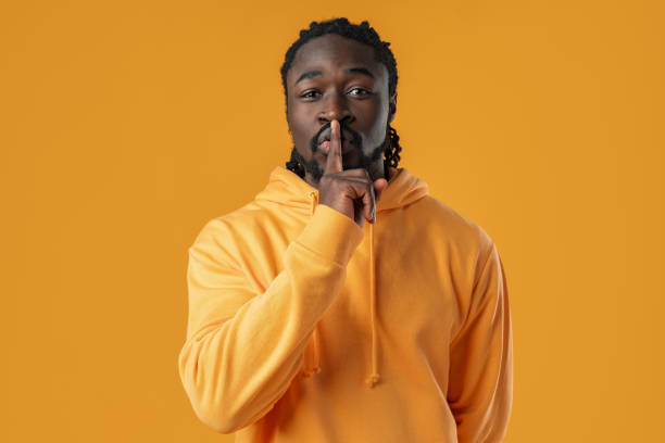 istock African man standing over yellow background showing silence gesture 1467024297