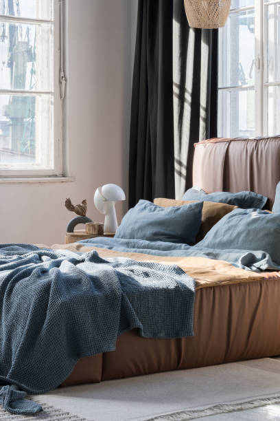 istock Sunny bedroom with big bed in brown leather frame 1467025046