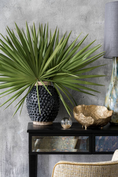 Unique vase with green leaves on console table
