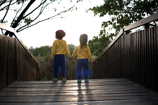 Playing on the wooden bridge with siblings in the afternoon