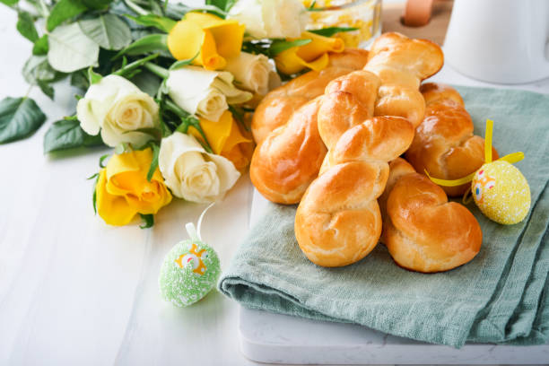 Easter breakfast Holliday concept. Easter bunny buns rolls with cinnamon made from yeast dough with orange glaze, easter decorations, colored eggs on white spring background. Easter Holliday card. desayuno de pascua concepto holliday. rollos de bollos de conejo de pascua con canela hechos de masa de levadura con glaseado naranja, decoraciones de pascua, huevos de colores sobre fondo blanco de primavera. tarjeta de vacaciones de pascua.